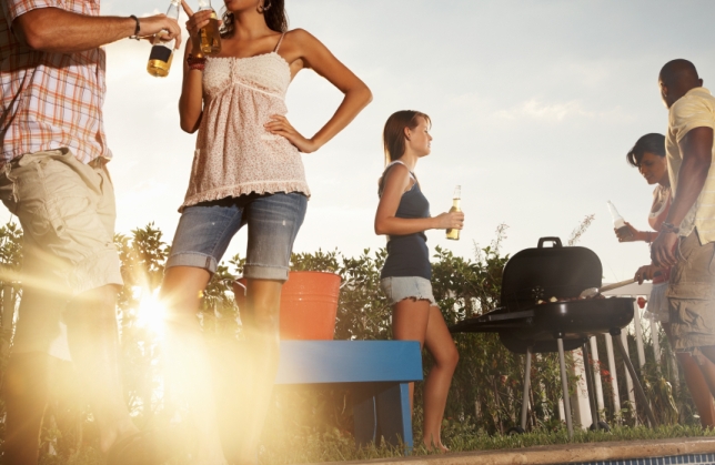 Group of multiracial friends with barbecue and beer bottle enjoying their vacation
